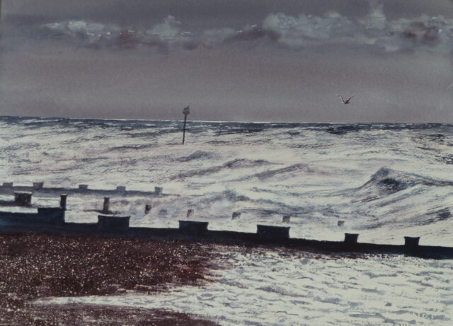 A watercolour painting of Bexhill Beach with stormy, winter waves breaking out onto the shingle beach and against the groynes