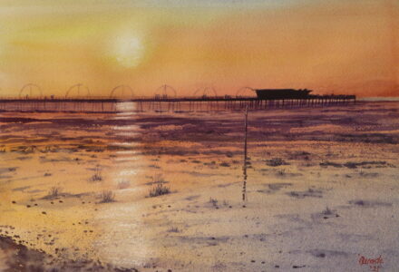 A watercolour painting of Southport pier as the sun sets over it and the sun is reflected in the bands of wet sand. Grasses and pebbles adorn the foreground beach.
