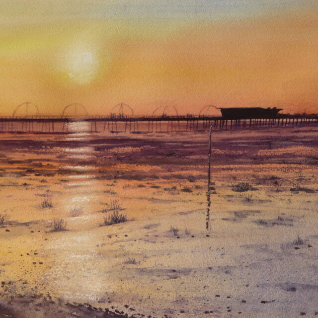 A watercolour painting of Southport pier as the sun sets over it and the sun is reflected in the bands of wet sand. Grasses and pebbles adorn the foreground beach.