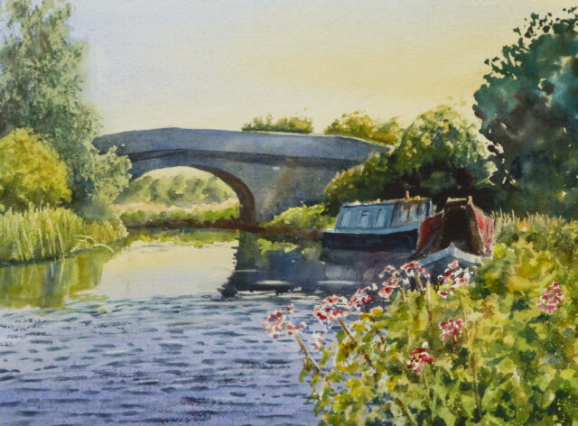 A watercolour painting of the Rufford Branch canal with moored narrowboats nestling up against the old arched stone bridge. Lush vegetation surround the banks and a breeze ripples the water.