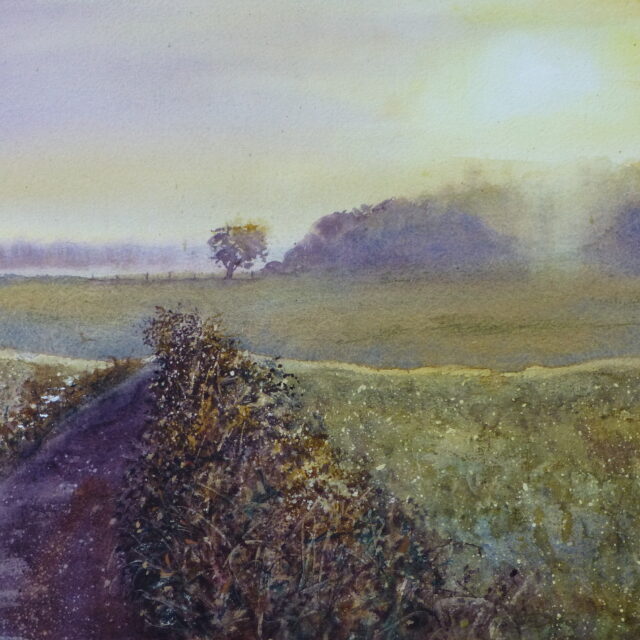 A watercolour painting of the sunrise as it comes over a copse on Clieves' Hills, outside Ormskirk. Mist hangs about distant trees and a lone tree stands by a fence in a field.