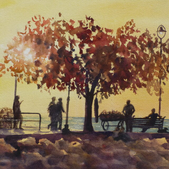 A watercolour painting of evening on a breakwater with revellers and vendors enjoying the last of a sunny day - some sitting under the spreading branches of a tree.