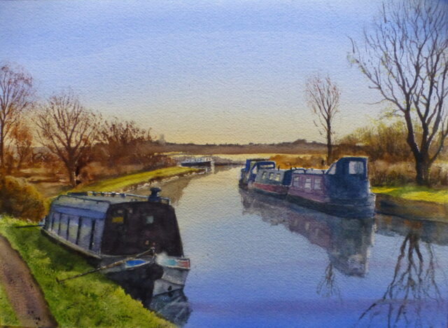 A watercolour painting of narrowboats moored on the Leeds/Liverpool canal at Burscough on a bright winter's day with reflections in the water.